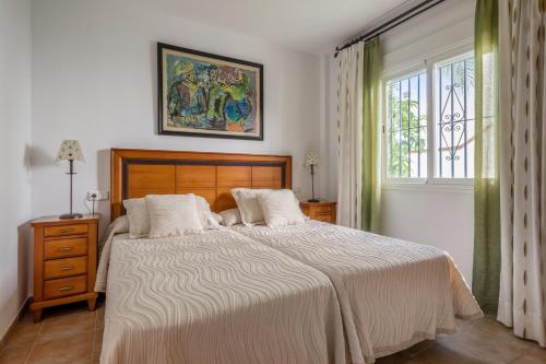 Un dormitorio con una cama grande y una ventana en 4 bedrooms house at Almunecar 400 m away from the beach with sea view private pool and furnished terrace, en Almuñécar