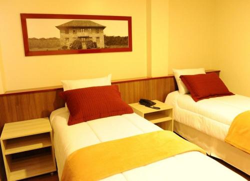 Un pat sau paturi într-o cameră la Imigrantes Hotel