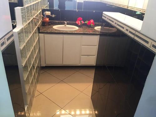 a bathroom with two sinks and a tiled floor at Elegant Villa with Sea View in Sosúa | Private Pool in Sosúa