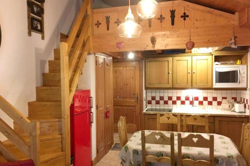 eine Küche mit Holzschränken und einem roten Kühlschrank in der Unterkunft Appartement de 2 chambres a Pralognan la Vanoise a 900 m des pistes avec balcon amenage et wifi in Pralognan-la-Vanoise
