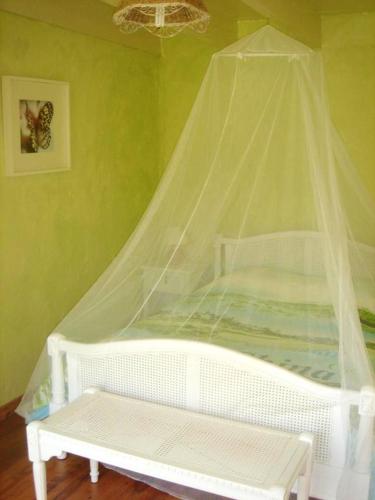 - un lit blanc avec moustiquaire dans l'établissement Maison confortable Bussac-Forêt + Piscine, à Bussac-Forêt