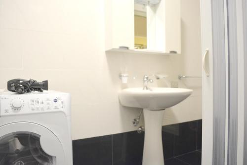 a bathroom with a sink and a washing machine at Charming apartment in Reggio Calabria, 40 sqm, terrace in Reggio Calabria