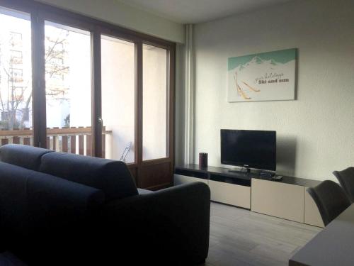 a living room with a couch and a flat screen tv at Appartement d'une chambre avec balcon amenage et wifi a Briancon in Briançon