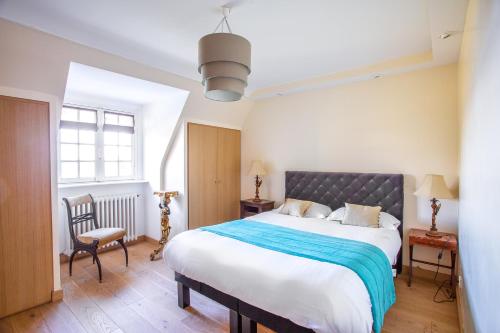 a bedroom with a large bed and a chair at Villa charmante à Roscoff avec vue sur la mer in Roscoff