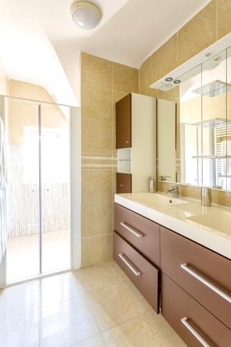 une salle de bain avec un lavabo et un miroir dans l'établissement Villa charmante à Roscoff avec vue sur la mer, à Roscoff