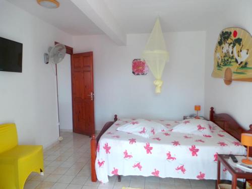 a bedroom with a bed and a tv in it at Maison charmante à Bouillante + Jardin in Bouillante