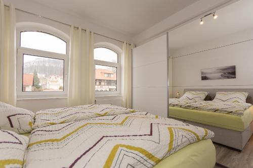 a bedroom with two beds and two windows at Traumferienwohnung in Sellin / Rügen in Ostseebad Sellin