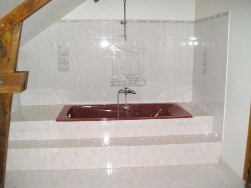 a bathroom with a red bath tub in a room at Villa spacieuse et conviviale à Courtenay avec jardin clôturé in Courtenay
