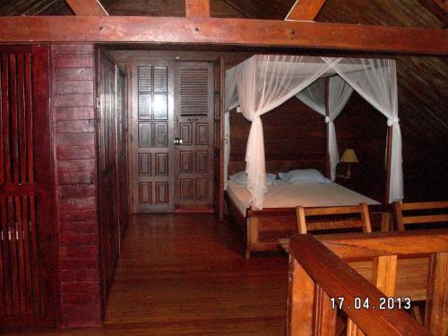 a bedroom with a bed with a mosquito net at 4 bedrooms house at Toamasina 50 m away from the beach with sea view and enclosed garden in Toamasina