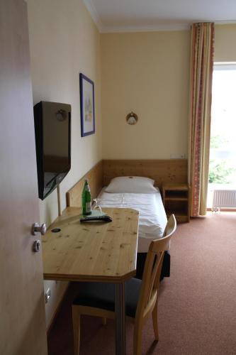 a hotel room with a bed and a table with a television at Hotel Pit Lane "Home of Motorsport" in Nürburg