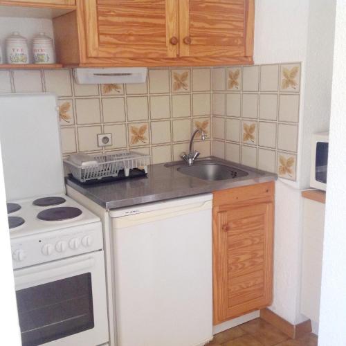 une petite cuisine avec un évier et une cuisinière dans l'établissement Appartement 2 chambres à Cavalaire-sur-Mer, 40 m² avec balcon, à Cavalaire-sur-Mer