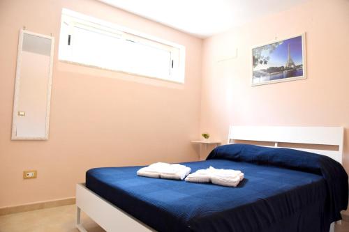 ein Schlafzimmer mit einem blauen Bett und Handtüchern darauf in der Unterkunft 2 bedrooms appartement at Capaccio Paestum 600 m away from the beach with enclosed garden and wifi in Capaccio-Paestum
