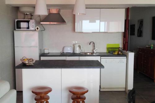 Una cocina con gabinetes blancos y un refrigerador blanco. en Comfortable apartment in Praia da Rocha 70 m² with sea view 4 pers, en Portimão