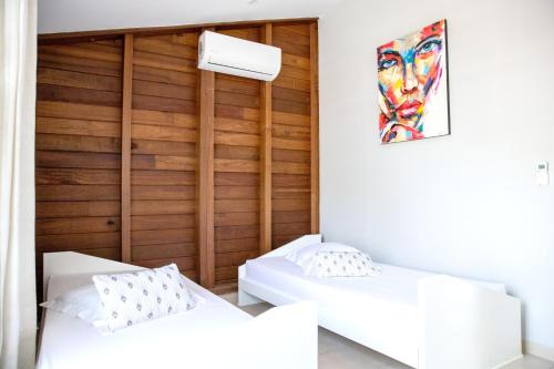 - 2 lits dans une chambre avec un mur en bois dans l'établissement Maison de 2 chambres avec sauna jardin clos et wifi a Sainte Anne a 5 km de la plage, à Sainte-Anne