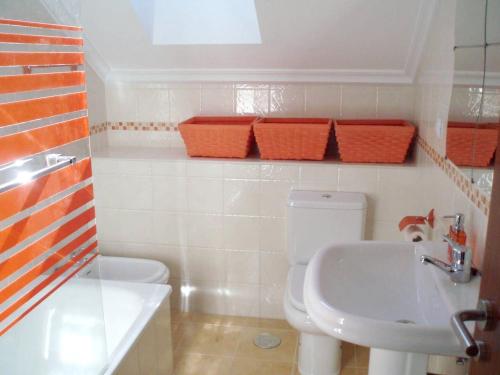 y baño con aseo blanco y lavamanos. en 2 bedrooms house with shared pool enclosed garden and wifi at Suances 5 km away from the beach en Suances