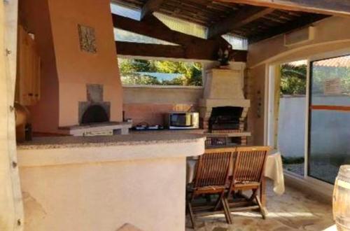 una cocina al aire libre con 2 sillas y una barra en Maison d'une chambre avec jardin clos et wifi a Martigues a 1 km de la plage, en Martigues