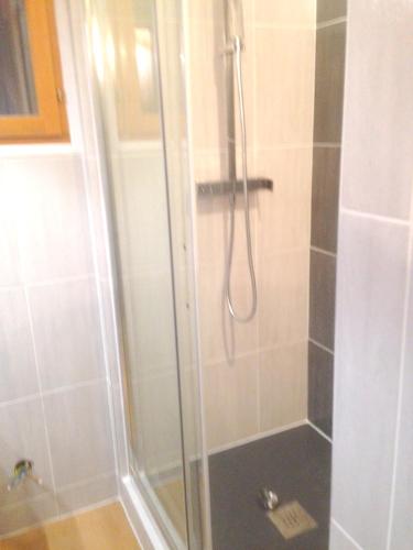 une douche avec une porte vitrée dans une salle de bain dans l'établissement Maison charmante à Martigues avec jardin et climatisation, à Martigues