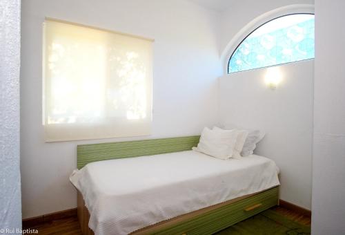 a small bedroom with a bed with a window at Charming House in Monchique with Shared Pool in Monchique