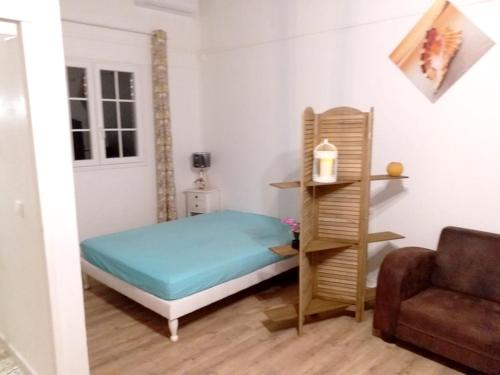 a small bedroom with a bed and a chair at Appartement d'une chambre avec jardin amenage et wifi a Petit Bourg in Petit-Bourg