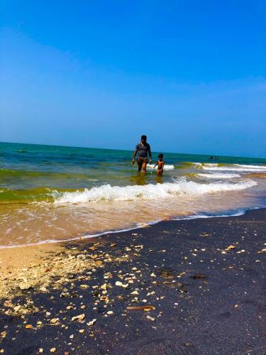 a man and a child playing in the water at the beach at Wilpattu Green Cabin in Achchamulai