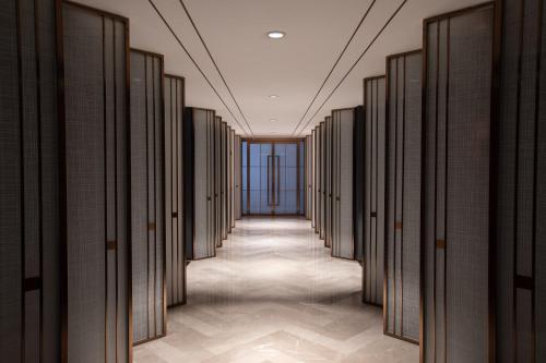 a hallway of doors in a building at Foreign Trade Centre C&D Hotel,Fuzhou in Fuzhou