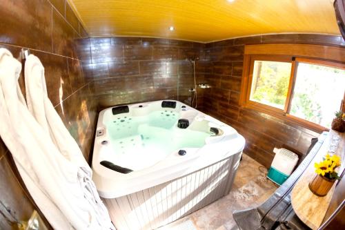 y baño con bañera y paredes de madera. en One bedroom house with shared pool jacuzzi and furnished terrace at Laroya, en Laroya