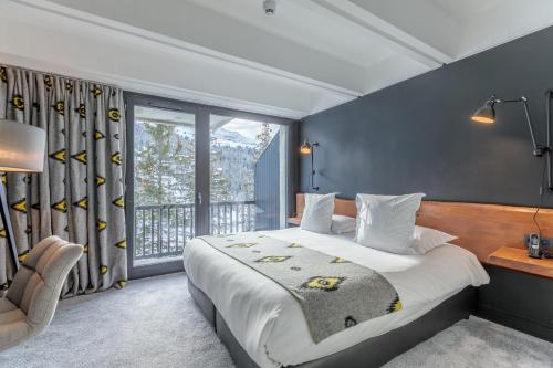 a bedroom with a large bed and a window at Totem, Friendly Hotel & Spa in Flaine