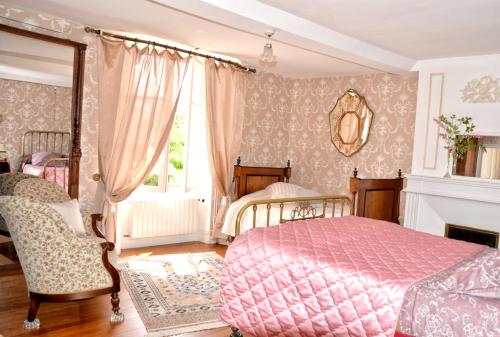 um quarto com uma cama rosa e uma lareira em Maison de 3 chambres avec vue sur la ville jardin clos et wifi a Ri em Ri