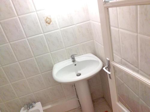 a bathroom with a white sink and a shower at Appartement charmant Morne-À-l'Eau in Morne-à-lʼEau