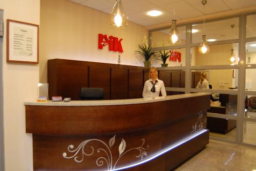 a woman standing in front of a large counter at Hotel Pik in Mikołów
