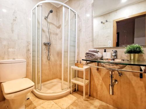 uma casa de banho com um chuveiro, um WC e um lavatório. em Bom dia Parque Nações LisboaZ em Lisboa