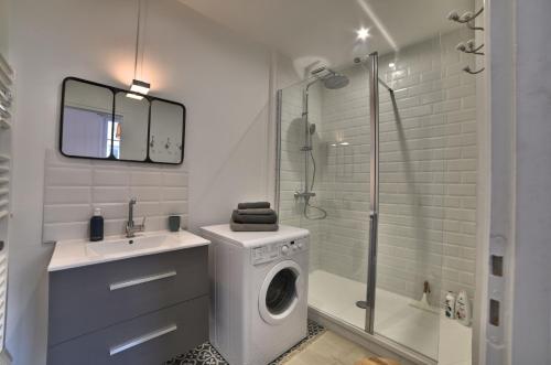 La salle de bains est pourvue d'un lave-linge et d'une douche. dans l'établissement Superbe T2 de 45m² en hyper centre, à La Rochelle