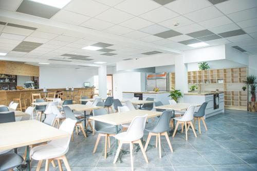 an empty restaurant with tables and chairs in it at BodyGo Hostel in Valfréjus