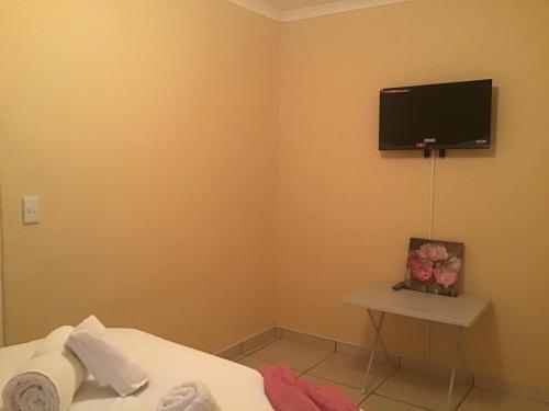 een hoek van een kamer met een tv aan de muur bij The Golden Rule Self Catering & Accommodation for guests in Keetmanshoop