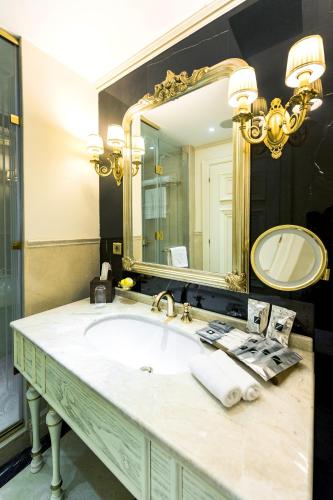 a bathroom with a sink and a large mirror at Rixos Khadisha Shymkent in Shymkent