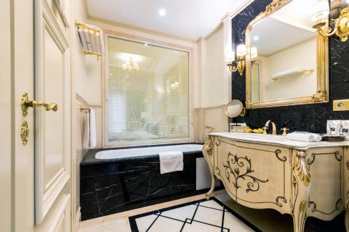 a bathroom with a sink and a mirror at Rixos Khadisha Shymkent in Shymkent