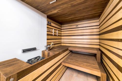 a sauna with wooden walls and benches in a room at Rixos Khadisha Shymkent in Shymkent