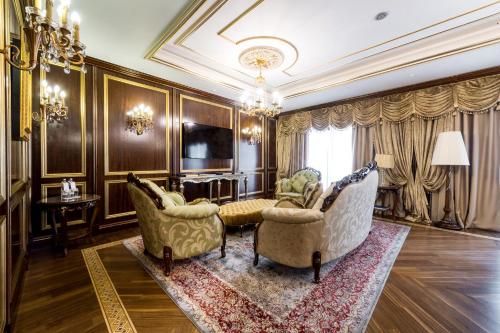 a living room with two chairs and a couch at Rixos Khadisha Shymkent in Shymkent