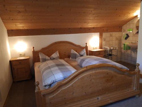 a bedroom with a large wooden bed with two pillows at Apartment Utschneider-Holzer in Bad Bayersoien