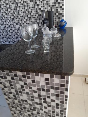 three wine glasses sitting on a counter in a bathroom at Apartamento Maria Farinha in Maria Farinha