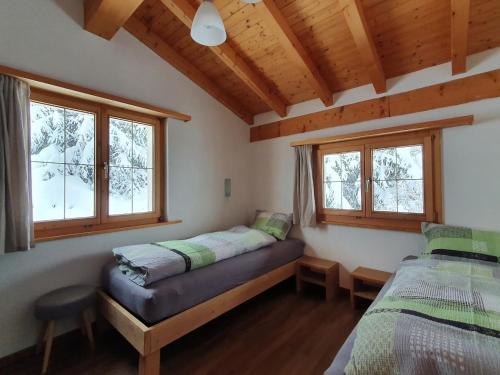 - une chambre avec 2 lits et 2 fenêtres dans l'établissement Tgampi saura 395 Rü, à Lenz