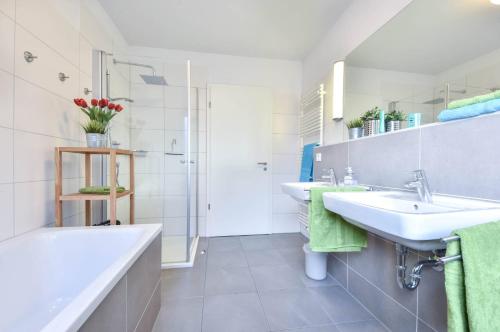 a white bathroom with two sinks and a shower at Villa Kaja Wohnung Kaiserbad in Korswandt