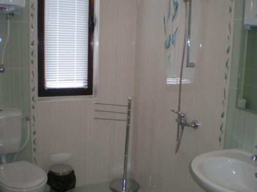 uma casa de banho com um WC, um lavatório e um chuveiro em Park Hotel Djevana em Gorna Oryakhovitsa