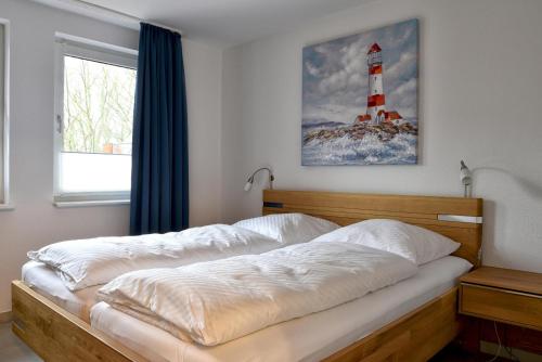 una camera da letto con un letto e un faro appeso al muro di Nordland Appartements Wohnung Bornholm a Wyk auf Föhr