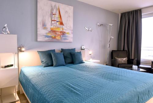 Schlafzimmer mit einem großen Bett mit blauer Decke in der Unterkunft Nordland Appartements Wohnung Aerö in Wyk auf Föhr