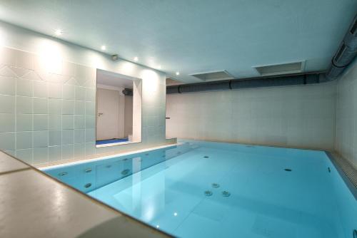 a large swimming pool in a room with a mirror at Nordland Appartements Wohnung Jütland in Wyk auf Föhr