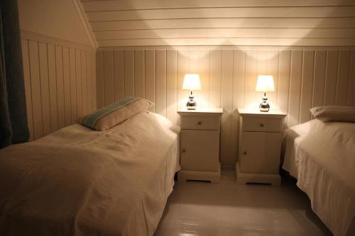 two beds in a room with two lamps on them at Skomakergarden in Ulsteinvik