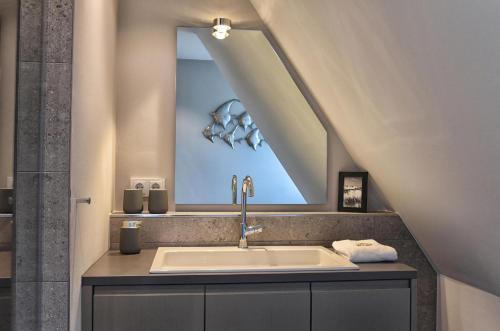 a bathroom with a sink and a skylight at Meggis Hues in Westerland (Sylt)