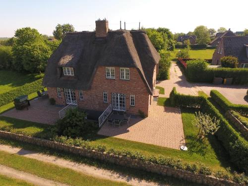 an old brick house with a thatched roof at Jettes Hus in Midlum