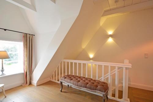 a staircase with a bench in a room at Reethus Doerpsend Haus 2 in Midlum